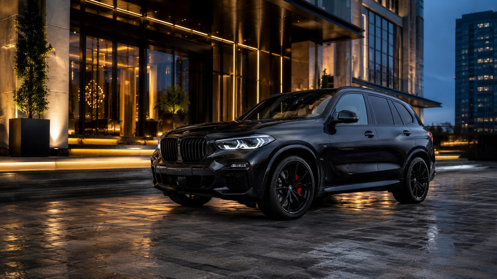 Czarne BMW X5 przed eleganckim hotelem